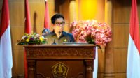 Bupati Badung I Wayan Adi Arnawa menyampaikan penjelasan terhadap Rancangan Peraturan Daerah (Ranperda) tentang Pertanggungjawaban Pelaksanaan APBD Tahun Anggaran 2025 kepada DPRD Kabupaten Badung dalam rapat paripurna, sebagai bentuk pertanggungjawaban pengelolaan keuangan daerah yang telah diaudit Badan Pemeriksa Keuangan (BPK) RI, bertempat di Ruang Sidang Utama Gosana, Gedung DPRD Badung, Senin, (06/07/2026). Rapat paripurna dipimpin Ketua DPRD Badung I Gusti Anom Gumanti, serta dihadiri Wakil Bupati Badung Bagus Alit Sucipta, Pimpinan beserta anggota DPRD Badung, Forkopimda Badung, Sekda Badung IB Surya Suamba serta Pimpinan Perangkat Daerah dilingkungan Pemkab Badung. Dalam penjelasannya, Bupati Adi Arnawa mengatakan, koordinasi Ranperda tersebut merupakan amanat Peraturan Pemerintah Nomor 12 Tahun 2019 dan Peraturan Menteri Dalam Negeri Nomor 77 Tahun 2020 yang mengatur Kepala Daerah wajib menyampaikan pertanggungjawaban pelaksanaan APBD kepada DPRD setelah laporan keuangan diaudit BPK. “Seluruh rangkaian pengelolaan keuangan daerah, mulai dari perencanaan, pelaksanaan, penatausahaan, pelaporan, pertanggungjawaban hingga pengawasan merupakan bagian dari upaya mewujudkan tata kelola pemerintahan yang baik dengan mengedepankan transparansi, akuntabilitas dan partisipatif,” kata Adi Arnawa. Ia menjelaskan pula, Laporan Keuangan Pemerintah Daerah (LKPD) Kabupaten Badung Tahun 2025 kembali memperoleh opini Wajar Tanpa Pengecualian (WTP) dari BPK RI Perwakilan Provinsi Bali. Capaian tersebut menjadi opini WTP ke-14 yang diraih Badung sejak pertama kali diperoleh pada laporan keuangan tahun 2011 serta mempertahankan predikat tersebut selama 12 tahun berturut-turut sejak 2014 hingga 2025. Berdasarkan hasil audit, realisasi pendapatan daerah pada tahun 2025 mencapai Rp. 9,107 triliun atau 81,13 persen dari target sebesar Rp. 11,226 triliun. Pendapatan Asli Daerah (PAD) terealisasi sebesar Rp. 8,063 triliun atau 79,20 persen dari target, sedangkan pendapatan transfer mencapai Rp. 1,043 triliun atau 99,94 persen dari target. Nanti kita memasang target tetap berdasarkan potensi, tapi juga tidak pesimistis. Karena dibalik kita memasang target yang mungkin melebihi realisasi sekarang itu sebagai upaya kita memotivasi Bapenda semakin agresif melakukan pendataan potensi pajak di badung,” terangnya. Sementara itu, realisasi belanja daerah mencapai Rp. 8,301 triliun atau 64,56 persen dari pagu anggaran sebesar Rp. 12,857 triliun. Belanja meliputi belanja operasi Rp. 4,866 triliun, belanja modal Rp. 2,082 triliun, transfer belanja Rp. 1,341 triliun, dan belanja tidak terduga Rp. 10,73 miliar. Dengan capaian tersebut, APBD Kabupaten Badung Tahun Anggaran 2025 mencatat surplus sebesar Rp. 806,53 miliar, berbalik dari target awal yang direncanakan mengalami defisit sebesar Rp 1,63 triliun. Selain itu, Sisa Lebih Pembiayaan Anggaran (SILPA) tercatat sebesar Rp. 1,192 triliun. Adi Arnawa berharap pembahasan Ranperda pertanggungjawaban APBD 2025 dapat berjalan sesuai mekanisme yang berlaku hingga diperoleh persetujuan DPRD. “Kami berharap dokumen pertanggungjawaban pelaksanaan APBD Tahun Anggaran 2025 ini dapat dibahas dan disetujui dalam masa konferensi ini sehingga semakin memperkuat tata kelola pemerintahan yang akuntabel serta memberikan manfaat bagi peningkatan kesejahteraan masyarakat Badung,” ujarnya.