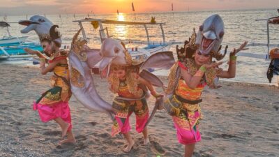 Pembukaan Lovina Festival 2026 menyedot perhatian ribuan pasang mata, baik wisatawan domestik maupun mancanegara. Di balik kemegahan panggung pembukaan yang sarat nuansa bahari, pemilihan Tari Nelayan Massal sebagai suguhan utama ternyata menyimpan filosofi mendalam. Kepala Dinas Kebudayaan dan Pariwisata (Disbudpar) Kabupaten Buleleng, Drs. I Nyoman Wisandika, membeberkan alasan kuat di balik keputusan menampilkan tarian kolosal tersebut pada upacara pembukaan. Menurutnya, pementasan secara massal ini bukan sekadar pertunjukan estetika semata, melainkan manifestasi dari jiwa masyarakat pesisir Bali Utara. "Kami sengaja mengangkat Tari Nelayan Massal sebagai salah satu suguhan utama di hari pembukaan Lovina Festival 2026 karena tarian ini memiliki filosofi yang sangat kuat dengan identitas asli masyarakat pesisir Lovina. Tarian ini bukan sekadar hiburan estetik, tetapi sebuah refleksi nyata atas denyut kehidupan, semangat gotong royong, serta keseharian nelayan lokal kita yang hidup berdampingan secara harmonis dengan laut," ujar I Nyoman Wisandika saat dikonfirmasi Sabtu,(25/7). Wisandika menjelaskan,,pementasan tersebut sangat selaras dengan tema besar yang diusung pada penyelenggaraan Lovina Festival tahun ini, yakni "Theatre of Dolphins". Unsur bahari dan kehidupan masyarakat pesisir sengaja diletakkan sebagai roh utama festival guna memperkuat karakter kawasan wisata Pantai Lovina.”Dengan melibatkan 165 penari secara massal yang dipusatkan di kawasan pesisir ikonik, pihaknya ingin langsung menyampaikan pesan budaya yang autentik, megah, sekaligus membanggakan kepada dunia internasional. Selain itu Tari Nelayan penciptanya dari Buleleng yaitu Desa Kedis, Kecamatan Busungbiu bernama Ketut Merdana” Melalui momentum ini, Disbudpar Buleleng berharap para wisatawan asing maupun domestik dapat melihat bahwa sektor pariwisata di kawasan Lovina tidak hanya menjual keindahan alam dan atraksi lumba-lumba saja. Lebih dari itu, pariwisata Buleleng dibangun di atas fondasi yang berakar kuat pada pelestarian tradisi dan kearifan lokal masyarakatnya (quality tourism). Kesiapan pementasan kolosal ini tidak lepas dari kerja keras para pengisi acara, salah satunya dari Sanggar Seni Shanti Budaya. Pembina Sanggar Seni Shanti Budaya, Ida Ayu Ketut Widya Utami, mengungkapkan bahwa persiapan penampilan Tari Nelayan Massal dilakukan secara intensif selama dua minggu sejak jadwal pementasan diumumkan secara resmi. Meski waktu yang tersedia relatif singkat, pihaknya segera mengoordinasikan para penari dan menyusun jadwal latihan agar seluruh peserta dapat tampil maksimal. Menurut Widya Utami, proses persiapan tidak hanya berfokus pada latihan koreografi, tetapi juga diawali dengan pemilihan personel karena para anggota sanggar berasal dari berbagai wilayah sehingga penyesuaian jadwal menjadi tantangan tersendiri. Setelah seluruh penari terkumpul, latihan rutin dilaksanakan hingga menjelang hari pementasan. Dalam perhelatan ini, Sanggar Seni Shanti Budaya mengirimkan sebanyak 30 penari untuk ambil bagian dalam Tari Nelayan Massal. Para peserta berasal dari berbagai jenjang pendidikan, mulai dari tingkat Sekolah Dasar (SD), Sekolah Menengah Pertama (SMP), hingga Sekolah Menengah Atas (SMA), yang dibina secara berkesinambungan di sanggar tersebut. Widya Utami menilai keikutsertaan dalam Lovina Festival merupakan kesempatan yang sangat berharga bagi para penari muda untuk menampilkan kemampuan sekaligus menjadi bagian dari upaya pelestarian dan promosi seni budaya Buleleng di kawasan wisata Lovina. Partisipasi generasi muda ini diharapkan mampu memperkuat eksistensi seni tradisi di tengah masyarakat sekaligus mendukung daya tarik festival sebagai agenda pariwisata unggulan Kabupaten Buleleng.