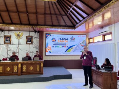 Untuk memperkuat tata kelola keamanan informasi di lingkungan Pemerintah Kabupaten Buleleng, Dinas Kominfosanti Kabupaten Buleleng melalui Bidang Persandian dan Statistik, mengembangkan inovasi RAKSA SANDI (Risiko, Aset, Keamanan dan Standarisasi Keamanan Informasi) yang merupakan Dashboard yang dikembangkan pada Portal ePUDAK (Sistem Pusat Data Aplikasi). Kepala Bidang Persandian dan Statistik, Komang Ery Marta Pariata, ST saat dihubungi di ruang kerjanya, Jumat (09/10) menyampaikan, RAKSA SANDI merupakan instrumen tata kelola keamanan informasi berbasis risiko yang dirancang untuk membantu organisasi dalam memetakan kondisi keamanan informasi, mengidentifikasi aset informasi strategis, menganalisis risiko, memantau kerentanan, mengendalikan mitigasi, serta mendukung penanganan insiden keamanan informasi secara lebih terintegrasi. "Inovasi ini hadir sebagai respons terhadap semakin meningkatnya ketergantungan penyelenggaraan pemerintahan terhadap teknologi informasi," Ungkap Ery Marta. Kondisi tersebut menuntut adanya pengelolaan keamanan informasi yang tidak hanya bersifat reaktif ketika terjadi insiden, tetapi juga mampu dilakukan secara preventif, terukur, berbasis risiko, dan berkelanjutan. Melalui RAKSA SANDI, informasi yang sebelumnya tersebar pada berbagai proses dan unit kerja diarahkan untuk dapat dipetakan secara lebih sistematis. Instrumen ini mengintegrasikan beberapa aspek penting, mulai dari inventarisasi aset, profil risiko, assessment keamanan, kerentanan sistem, backup, penanganan insiden, mitigasi, hingga review dan evaluasi keamanan informasi. "RAKSA SANDI dikembangkan melalui beberapa pusat pengelolaan informasi, yaitu Assessment Center, Vulnerability Center, Backup Center, Incident Response Center, dan Review Center. Masing-masing pusat memiliki fungsi yang saling terhubung untuk memberikan gambaran kondisi keamanan informasi secara lebih menyeluruh," tambah Ery Marta. Keberadaan RAKSA SANDI juga diharapkan dapat memperkuat koordinasi antara Dinas Kominfosanti, pengelola sistem informasi perangkat daerah, BULELENGKAB-CSIRT, serta pemangku kepentingan lainnya, seperti Inspektorat termasuk dalam proses identifikasi risiko, serta tindak lanjut kerentanan, penanganan insiden, dan evaluasi pengamanan sistem informasi. Selain mendukung pengelolaan teknis keamanan informasi, RAKSA SANDI dirancang sebagai instrumen pendukung pengambilan keputusan pimpinan. Data dan informasi yang tersaji dapat membantu menentukan prioritas pengamanan berdasarkan tingkat risiko, kondisi aset, kerentanan, serta kebutuhan mitigasi masing-masing sistem informasi. Dalam pengembangannya, RAKSA SANDI juga diarahkan untuk mendukung pengukuran dan penguatan keamanan informasi melalui Indeks Keamanan Informasi (KAMI) dan Indeks Kematangan Keamanan Siber dan Sandi (IKASANDI) serta penguatan koordinasi dengan pihak terkait yang menjadi instrumen penilaian indeks Pemerintah Digital (PEMDI). "Dengan pendekatan tersebut, RAKSA SANDI diharapkan tidak berhenti sebagai sebuah dashboard atau aplikasi, tetapi menjadi instrumen perubahan cara kerja dalam tata kelola keamanan informasi Pemerintah Kabupaten Buleleng—dari yang sebelumnya bersifat reaktif menuju pengelolaan yang lebih terencana, terukur, kolaboratif, dan berbasis risiko," tutup Ery Marta. Melalui implementasi RAKSA SANDI, Dinas Kominfosanti Kabupaten Buleleng berkomitmen untuk terus mendorong terwujudnya tata kelola keamanan informasi yang aman, andal, terintegrasi, adaptif, dan berkelanjutan, guna mendukung penyelenggaraan pemerintahan digital di Kabupaten Buleleng.